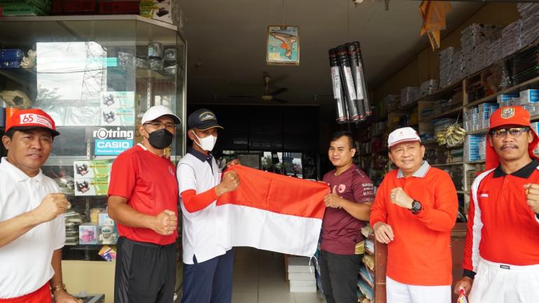Tampak sekda hamka membagikan bendera merah putih