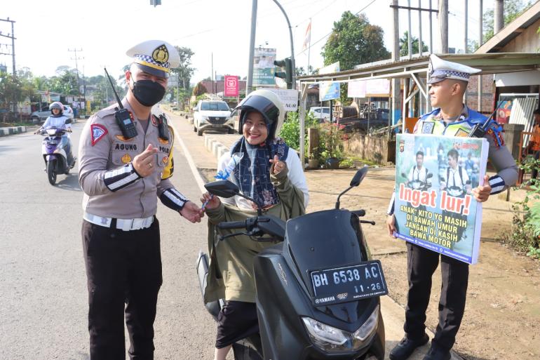 Kasatlantas memberikan bunga kepada pengendara motor(Hadi su/foto)